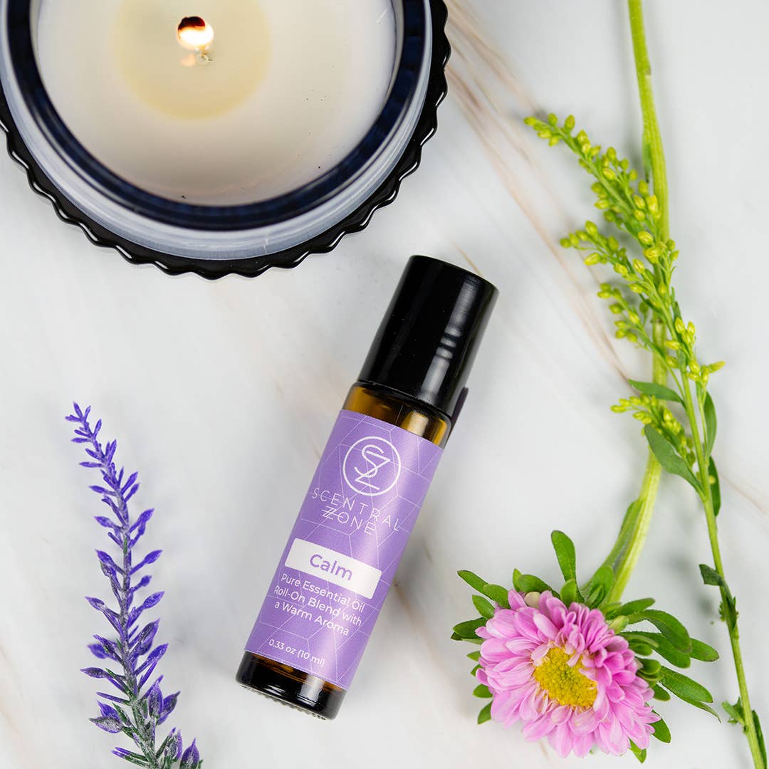 Essential oil bottle labeled 'Calm' with a candle, lavender, and flowers on a white background