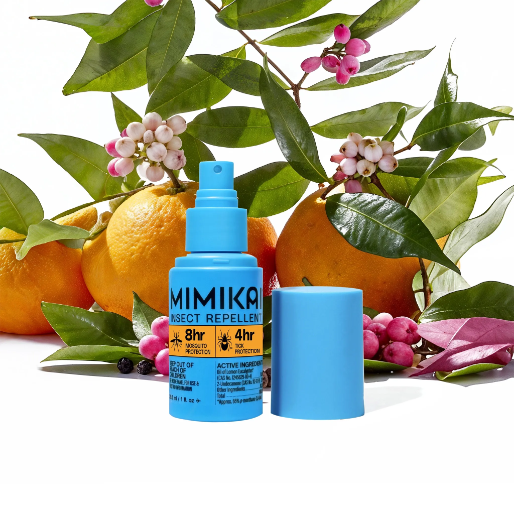 Blue insect repellent spray bottle on a white background with green leaves and oranges.