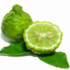 Bergamot Green fruit with a cut half on green leaves