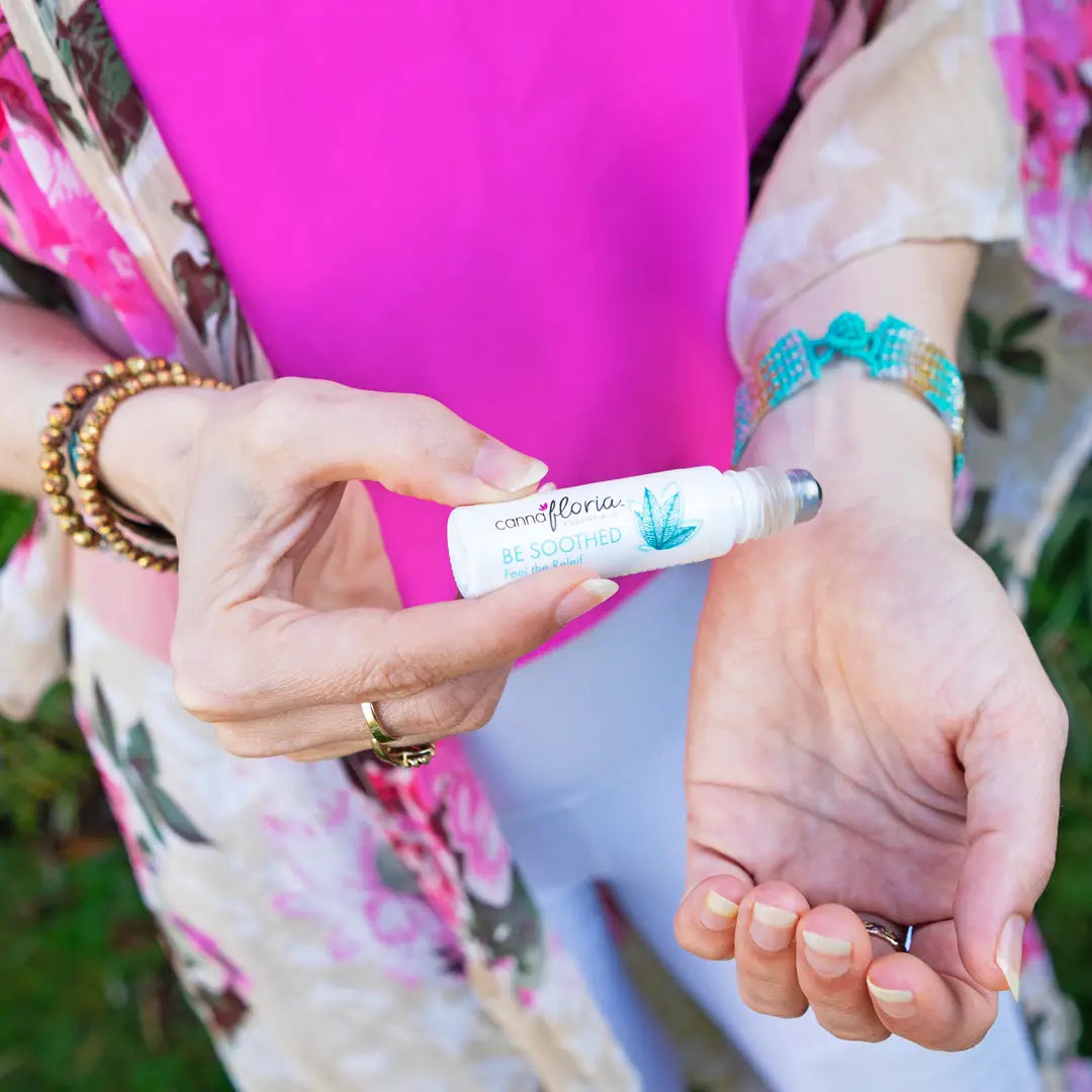 Woman applying Be Soothed Roll On Essential Oil Blend